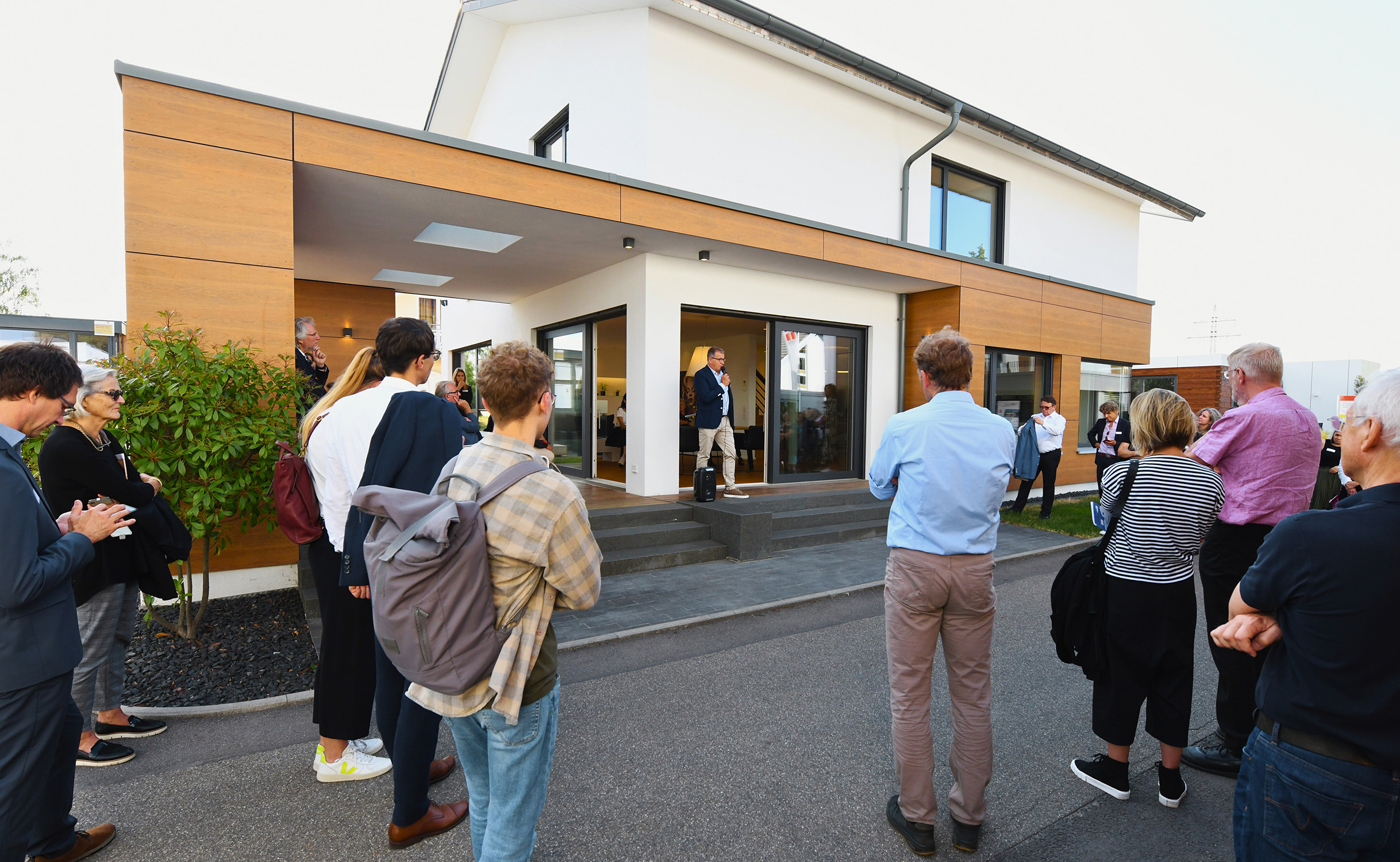 Menschen stehen vor einem Einfamilienhaus